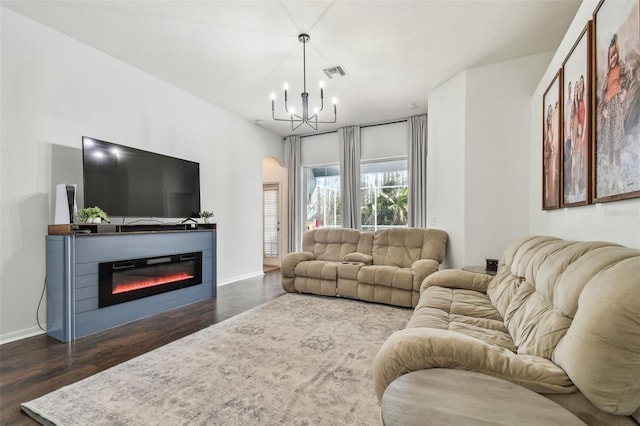 living room featuring an inviting chandelier and dark hardwood / wood-style flooring