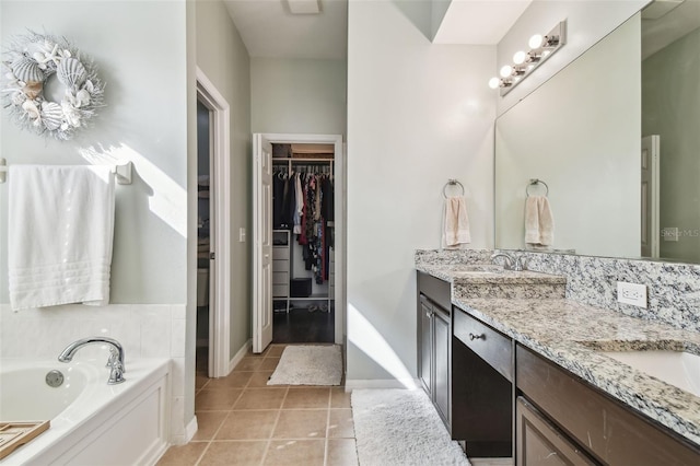 bathroom featuring tile patterned flooring, vanity, and a tub