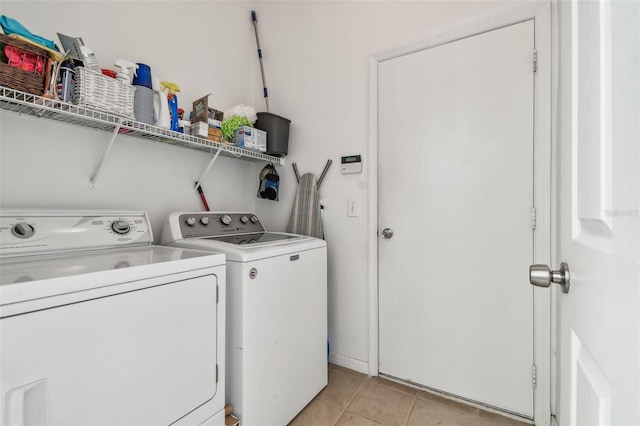 laundry area featuring light tile patterned floors and washing machine and dryer