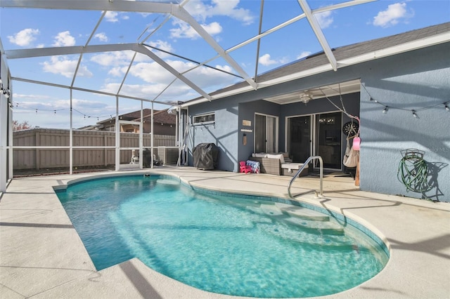 view of pool with a lanai, ceiling fan, and a patio area