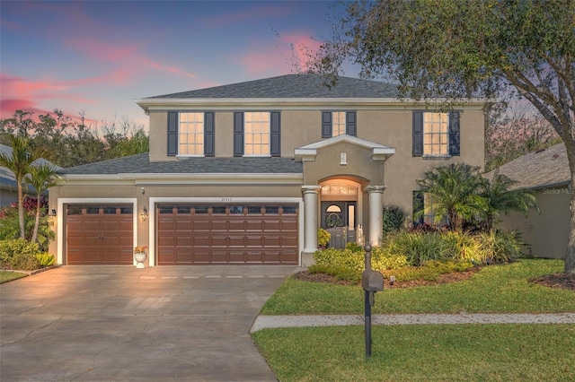 view of property with a garage and a yard