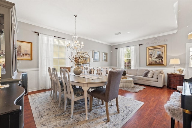 dining space with crown molding, a chandelier, and dark hardwood / wood-style flooring