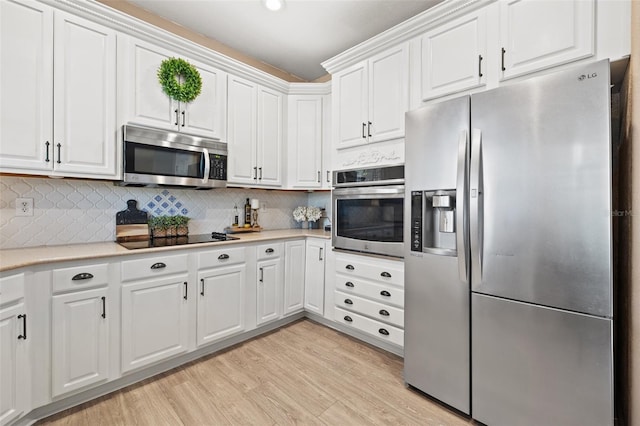 kitchen featuring white cabinetry, appliances with stainless steel finishes, light hardwood / wood-style floors, and tasteful backsplash