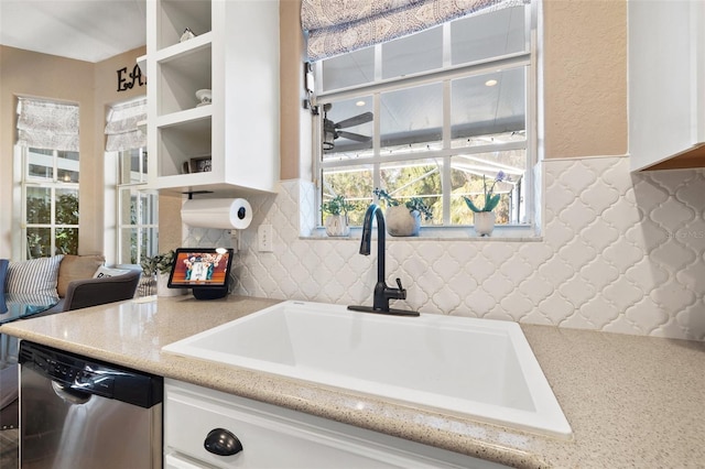 kitchen with dishwasher, sink, and light stone counters