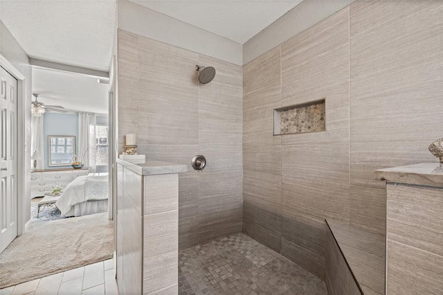 bathroom featuring a tile shower and ceiling fan