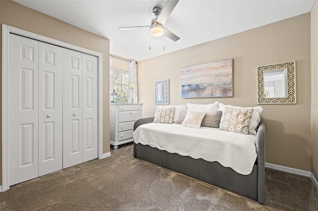 bedroom with dark colored carpet, ceiling fan, and a closet