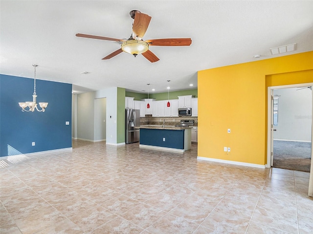 unfurnished living room with ceiling fan with notable chandelier