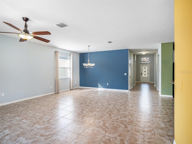 spare room with ceiling fan with notable chandelier and a textured ceiling