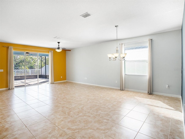 empty room with light tile patterned floors, ceiling fan with notable chandelier, and a textured ceiling