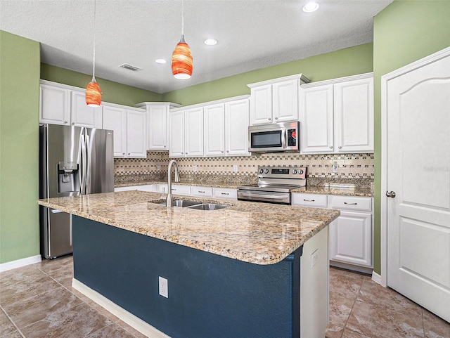 kitchen with sink, decorative light fixtures, white cabinets, and appliances with stainless steel finishes