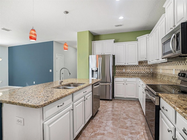 kitchen featuring appliances with stainless steel finishes, pendant lighting, white cabinetry, sink, and a center island with sink