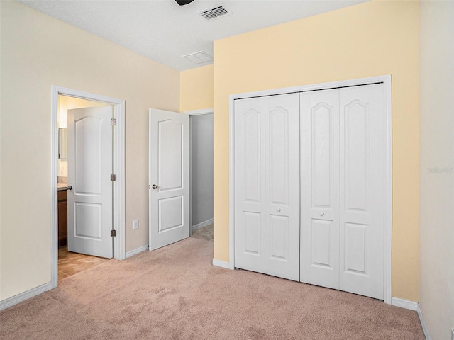 unfurnished bedroom featuring light colored carpet and a closet