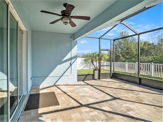 unfurnished sunroom with ceiling fan