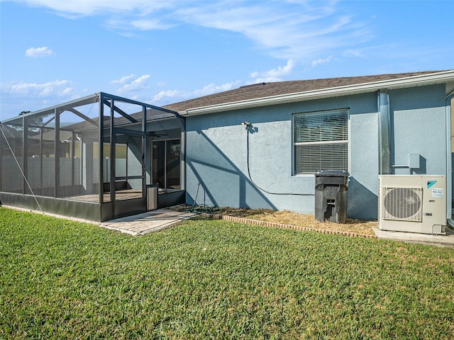 rear view of property with a yard, ac unit, and a lanai