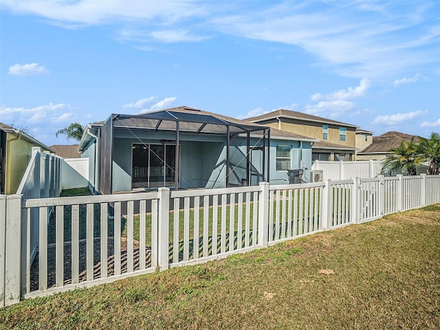 exterior space with a front yard and glass enclosure