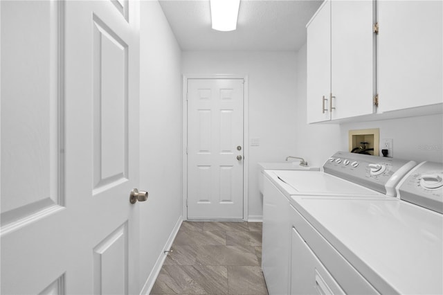 clothes washing area featuring cabinets, washing machine and dryer, and a textured ceiling