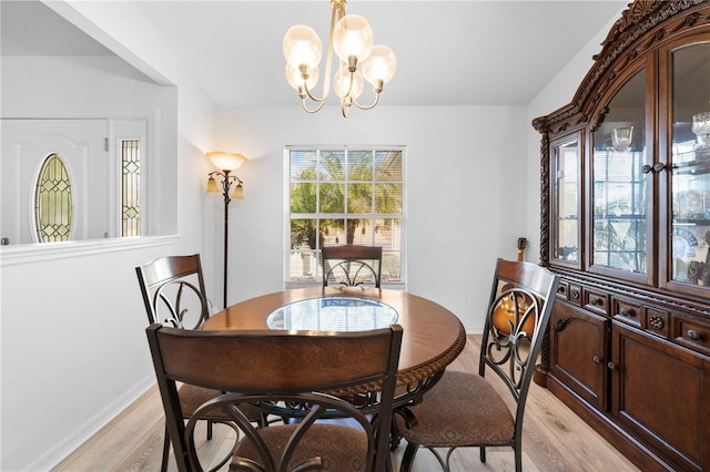 dining space with an inviting chandelier, a wealth of natural light, and light hardwood / wood-style floors