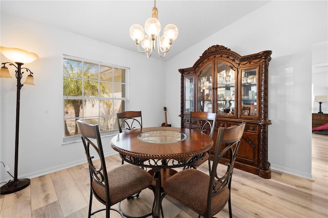 dining space featuring lofted ceiling, a chandelier, and light hardwood / wood-style flooring