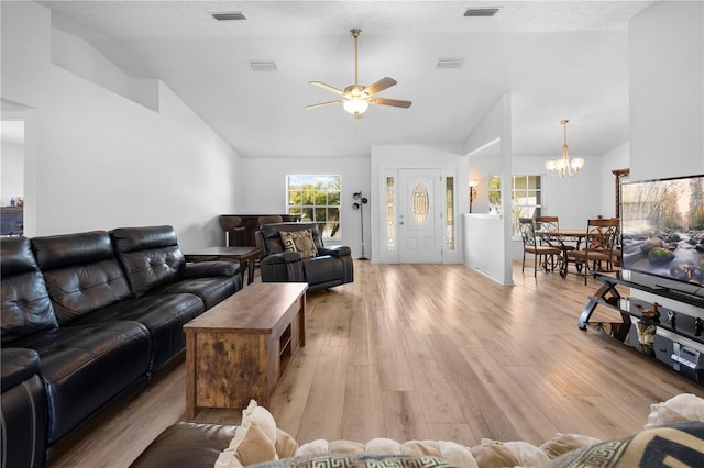 living room with high vaulted ceiling, ceiling fan with notable chandelier, and light wood-type flooring