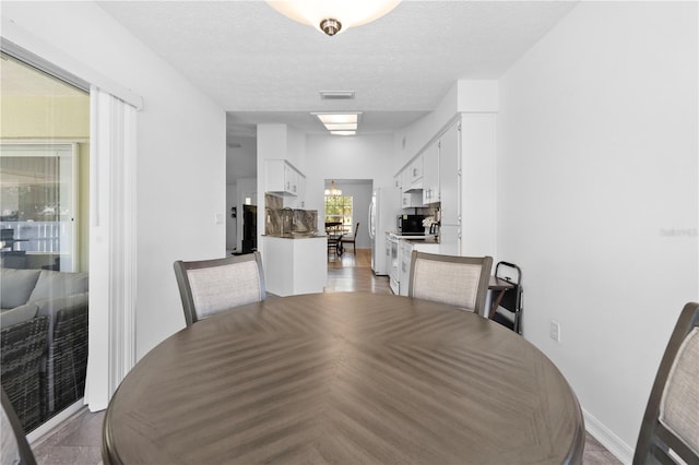 dining space featuring a chandelier and a textured ceiling