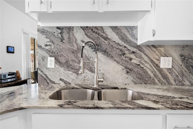 kitchen featuring sink, decorative backsplash, and white cabinets