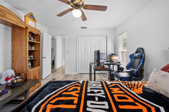 bedroom featuring ceiling fan, a textured ceiling, and light hardwood / wood-style flooring