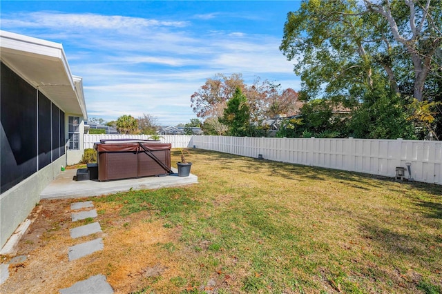 view of yard featuring a sunroom, a hot tub, and a patio