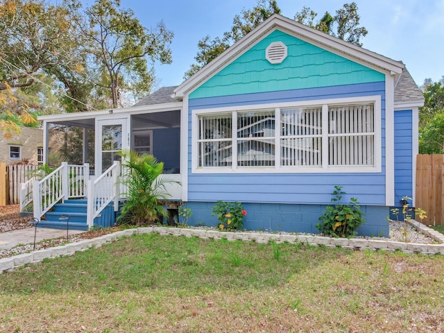 bungalow with a front yard and a sunroom