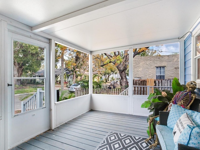 unfurnished sunroom with beam ceiling