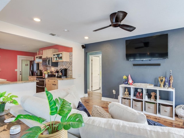 living room featuring light hardwood / wood-style floors and ceiling fan