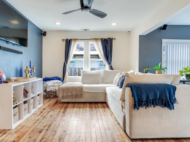 living room with ceiling fan and light hardwood / wood-style flooring