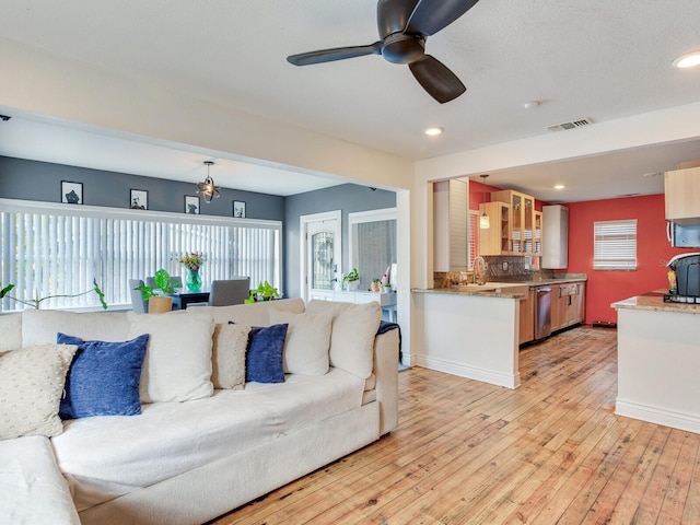 living room featuring ceiling fan, a healthy amount of sunlight, and light hardwood / wood-style floors