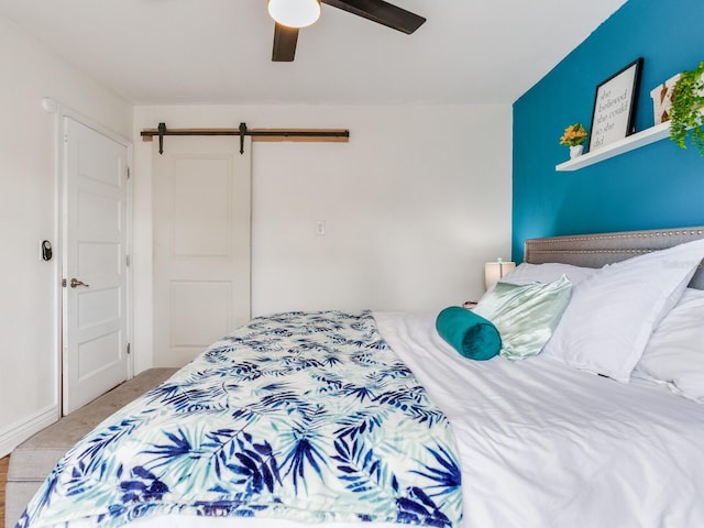 bedroom featuring a barn door and ceiling fan