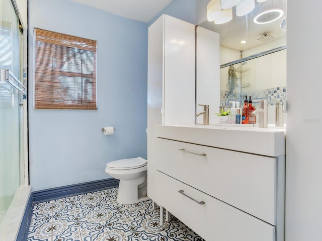 bathroom with tile patterned flooring, vanity, a shower with door, and toilet