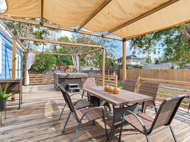 deck featuring a hot tub and a pergola