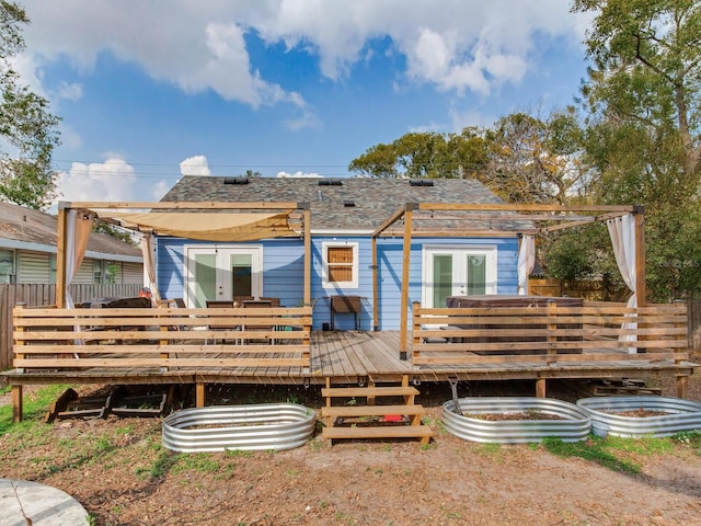 rear view of house featuring a wooden deck and french doors