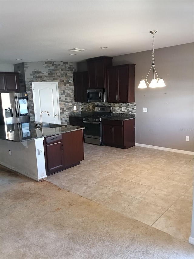 kitchen with pendant lighting, sink, stainless steel appliances, tasteful backsplash, and dark brown cabinetry