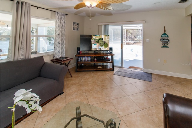 living room featuring light tile patterned floors, a healthy amount of sunlight, and ceiling fan