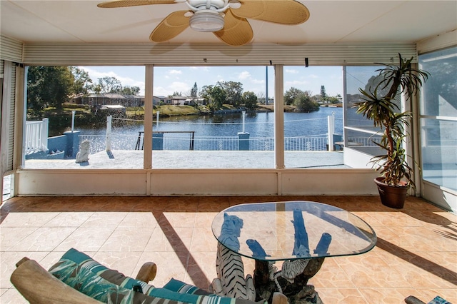 sunroom featuring a water view, ceiling fan, and a healthy amount of sunlight