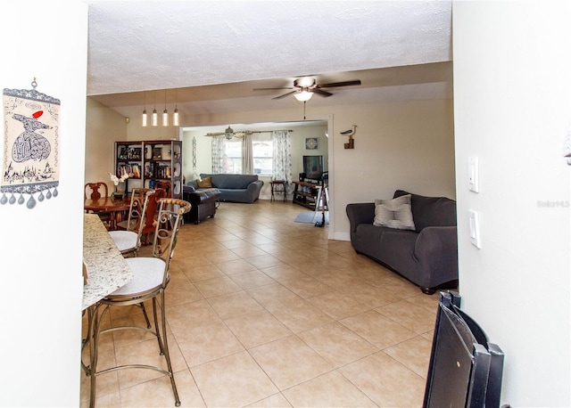 tiled living room with a textured ceiling and ceiling fan