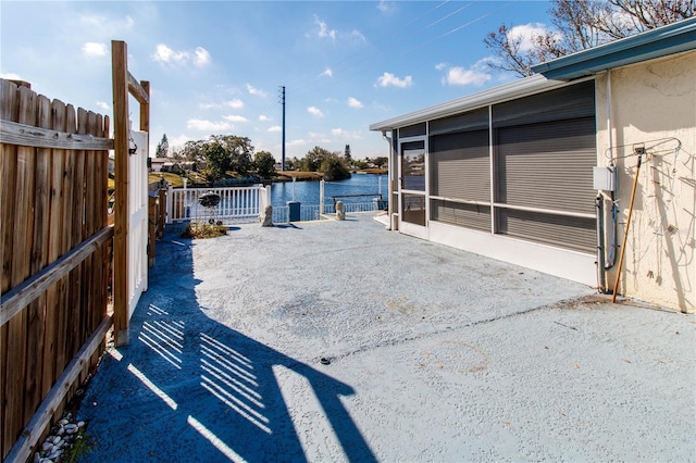 view of patio / terrace featuring a water view and a sunroom