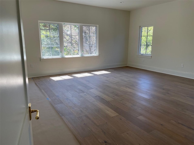 empty room featuring dark wood finished floors and baseboards