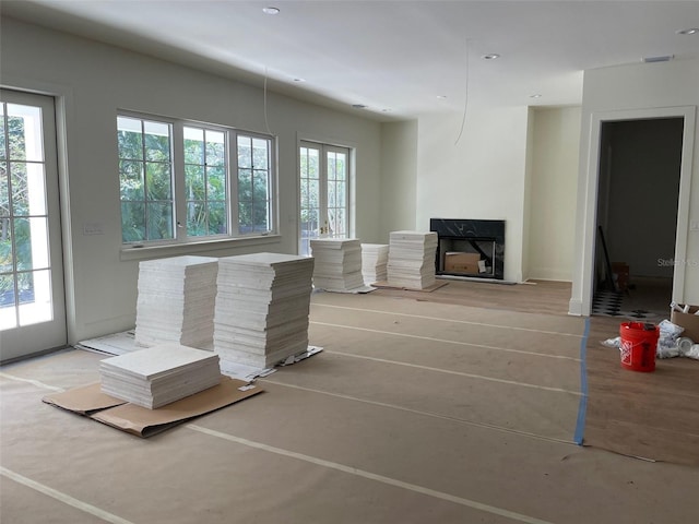 unfurnished living room featuring visible vents, a healthy amount of sunlight, and a fireplace