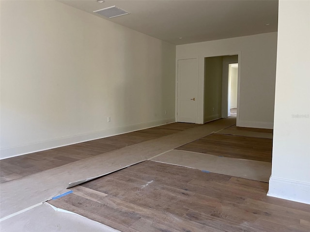 empty room featuring wood finished floors and baseboards