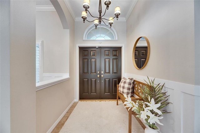 entryway featuring ornamental molding and an inviting chandelier