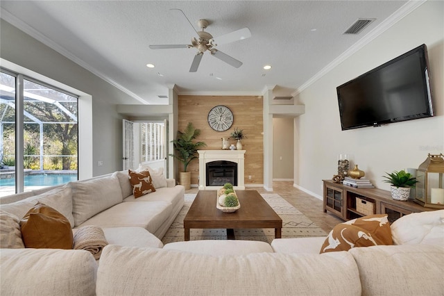 living room with crown molding, ceiling fan, a textured ceiling, and wood walls