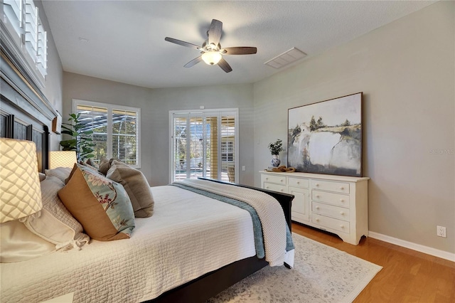 bedroom featuring ceiling fan, access to exterior, and light hardwood / wood-style flooring