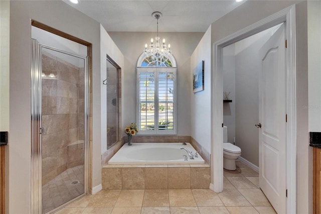 bathroom featuring an inviting chandelier, toilet, tile patterned flooring, and plus walk in shower