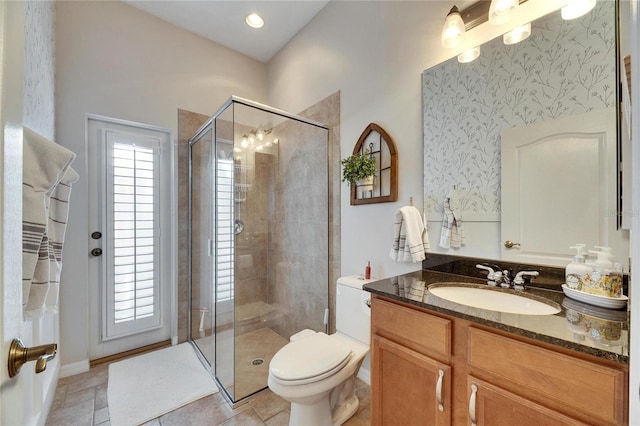 bathroom with walk in shower, vanity, and toilet