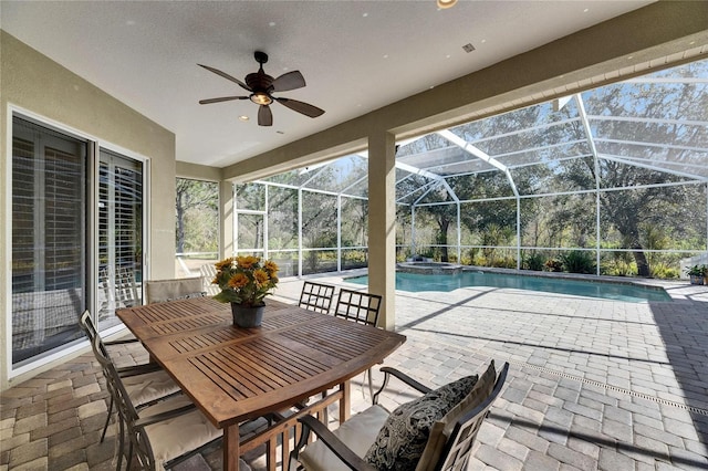 view of patio featuring ceiling fan and glass enclosure